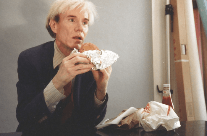 Andy Warhol eating a cheeseburger